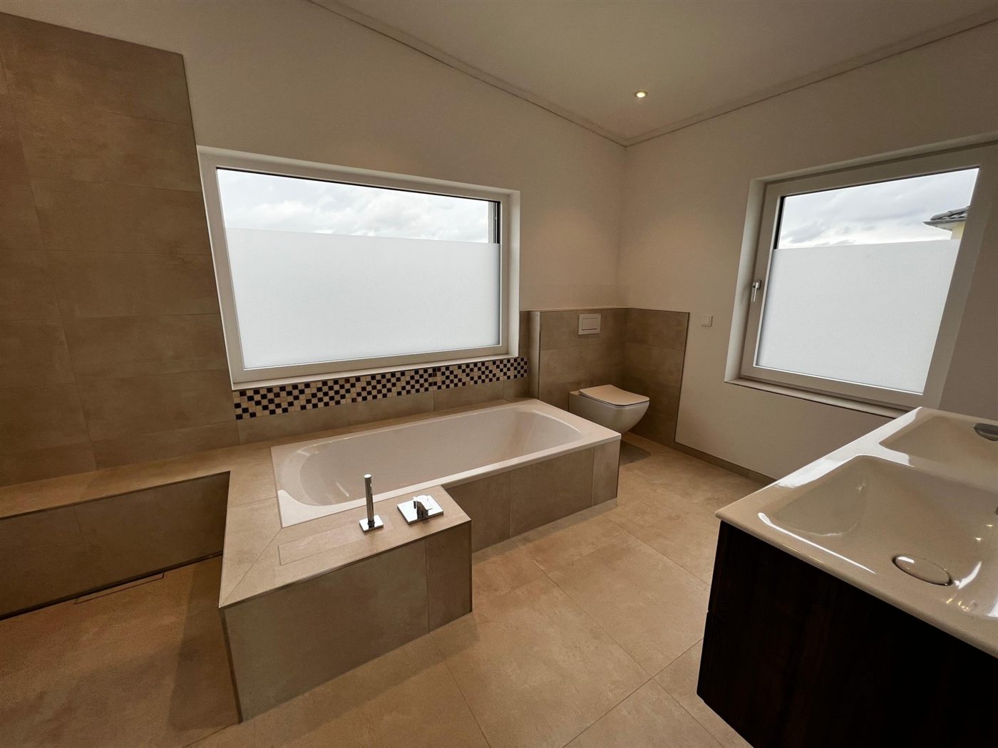 Badezimmer mit Badewanne und großformatigen Fliesen – Projektfoto