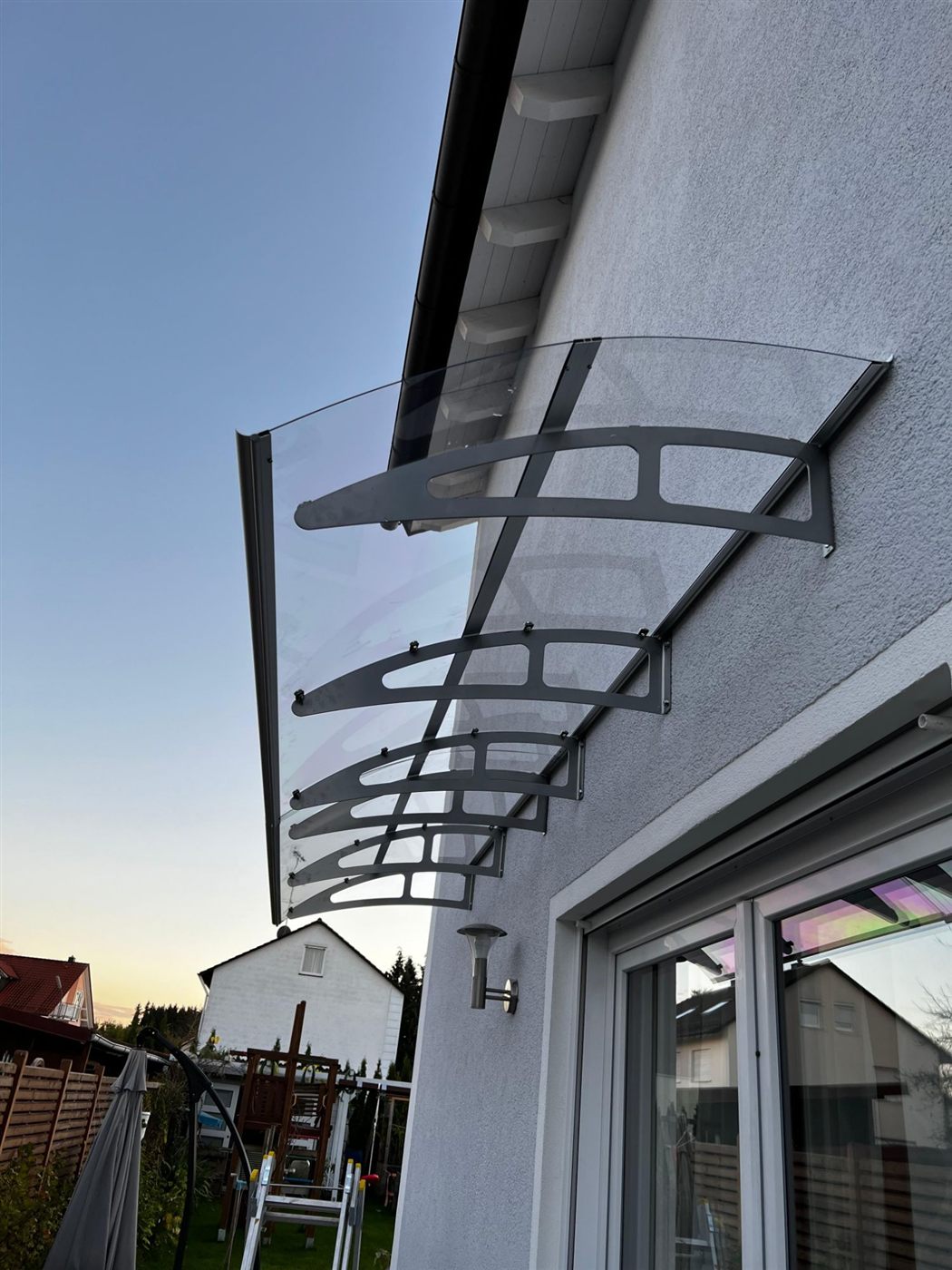 Montiertes Glas-Vordach mit Edelstahlkonsolen an einer Hausfassade