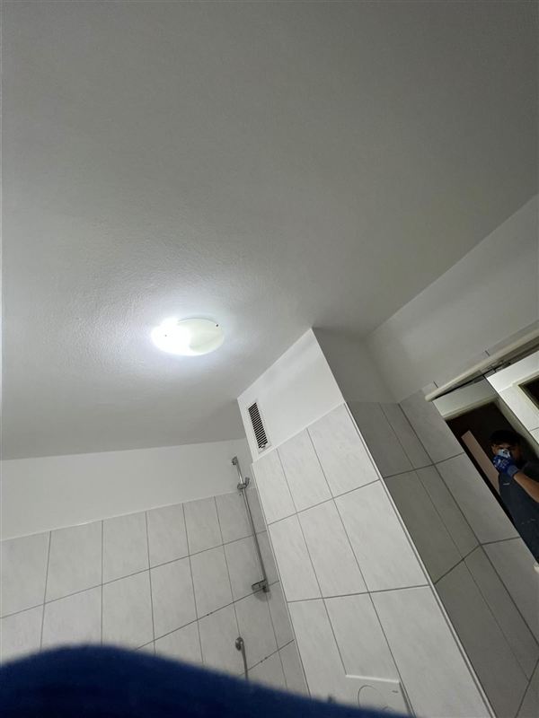 Frisch gestrichene Decke in einem Badezimmer mit Deckenleuchte